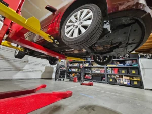 red-car-hoisted-with-single-post lift